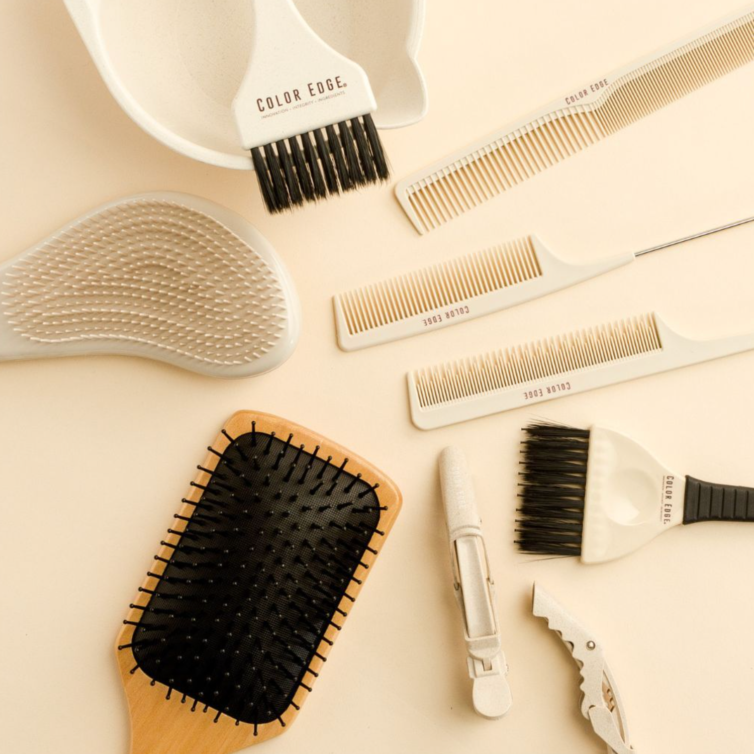 Collection of Color Edge brushes and combs on a beige surface