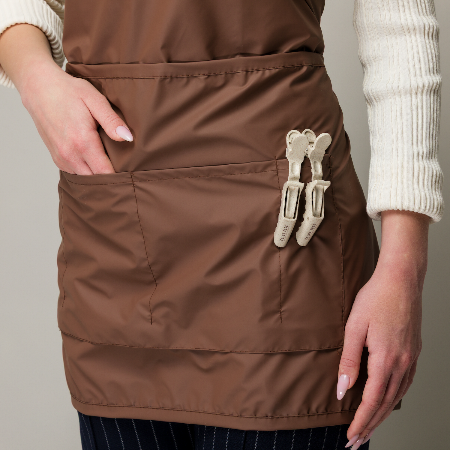 Hair clips clipped in the pockets of the Impulsive Color Apron