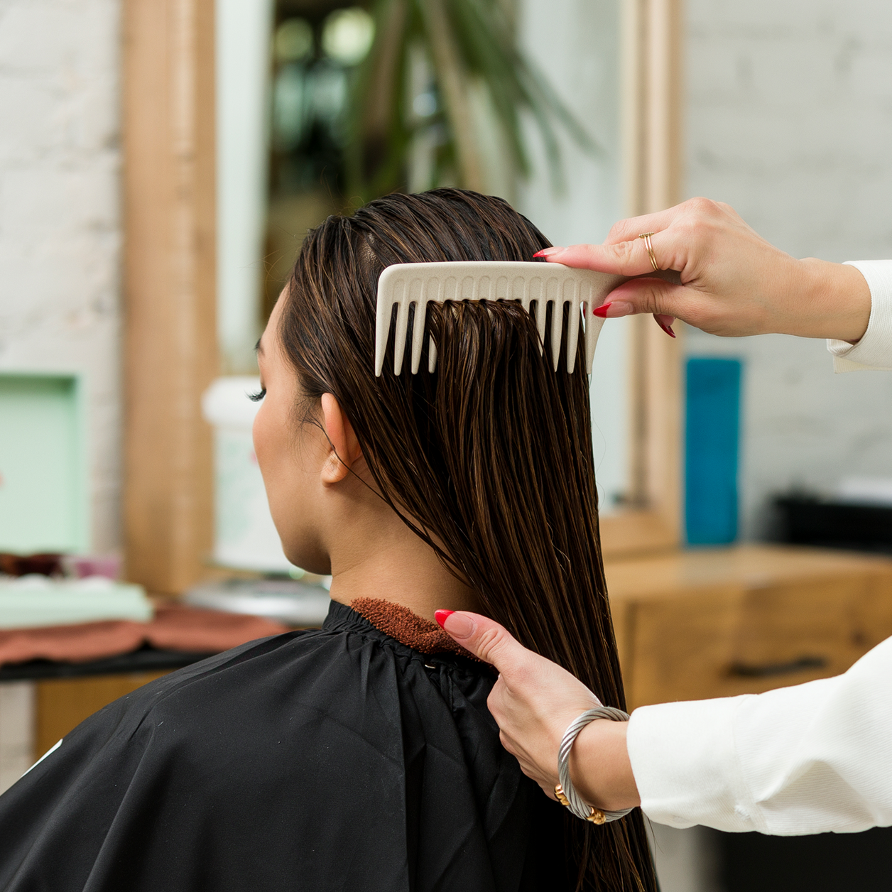 Stylist combing client's hair with Wide Tooth Comb