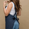 Blue denim pinstriped apron. Closeup details of the tie back