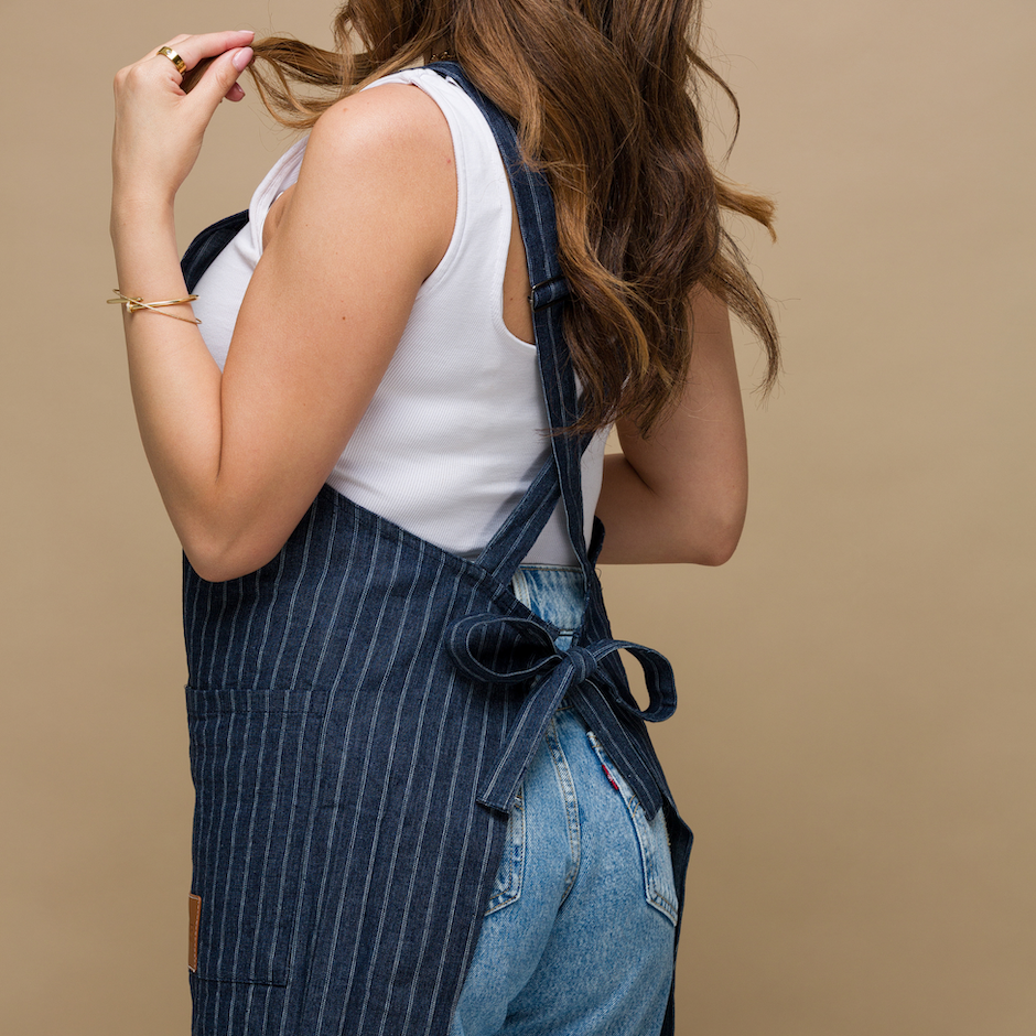 Blue denim pinstriped apron. Closeup details of the tie back